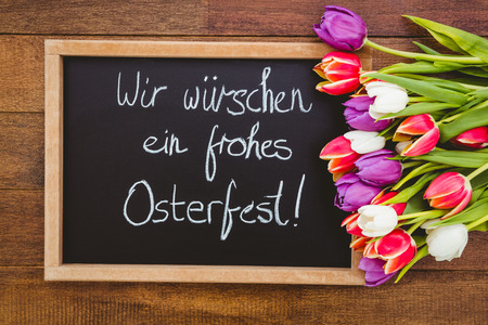 Bouquet of colored flowers against black board on wood deskの写真素材