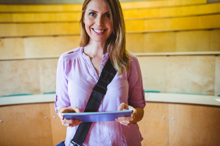 Mature student in lecture hall using tablet at the universityの写真素材