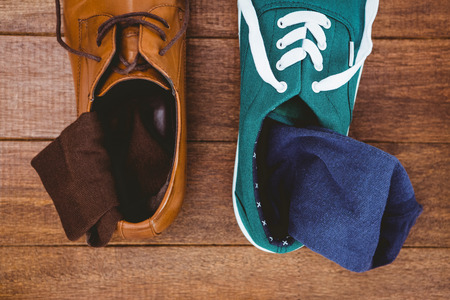 View of two different shoes on wood plankの写真素材
