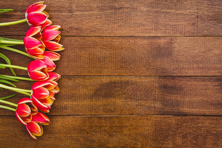 Bouquet of red beautiful flowers on wood deskの写真素材