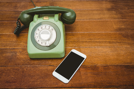 View of an old phone and a smartphone on wood deskの写真素材