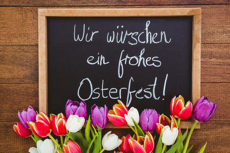 Bouquet of colored flowers against black board on wood deskの写真素材