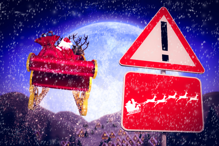 Christmas road sign against christmas village under full moonの写真素材