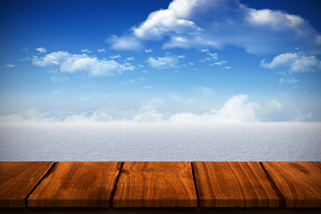 Wooden table against snowy landscape under blue skyの写真素材