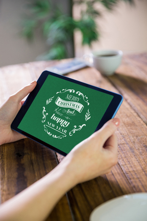 Woman using tablet pc  against christmas greeting