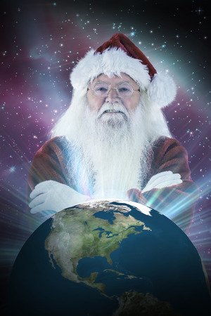 Santa smiles with folded arms against aurora shimmering in night skyの写真素材