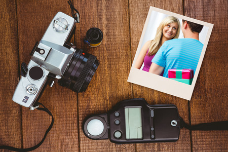 cute boyfriend giving a present  against view of an old camera with photo flashの写真素材