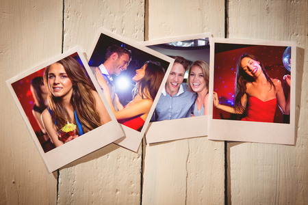 Instant photos on wooden floor against pretty brunette dancing and smilingの写真素材