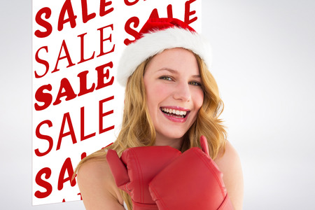 Smiling blonde wearing red boxing gloves against sale advertisementの写真素材