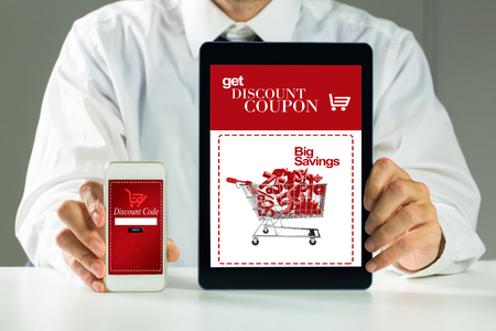 Businessman showing tablet pc and smartphone against sale advertisementの写真素材