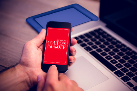 Sale advertisement against cropped image of person using mobile phone