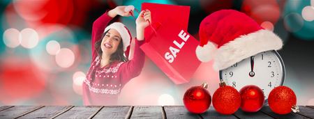 Pretty brunette showing sale bag and shopping bag  against digitally generated grey wooden planksの写真素材
