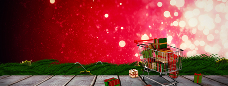 Trolley full of gifts against digitally generated grey wooden planksの写真素材