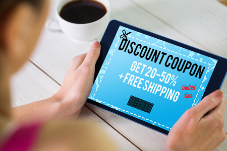 Woman using tablet pc against sale advertisementの写真素材