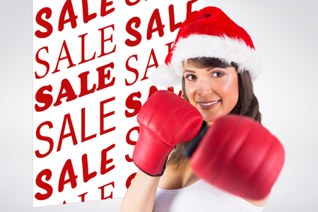 Festive brunette punching with boxing gloves against sale advertisementの写真素材