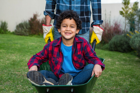 Smiling child in the barrow in the gardenの写真素材