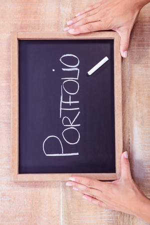 Chalkboard with portfolio text on wood deskの写真素材