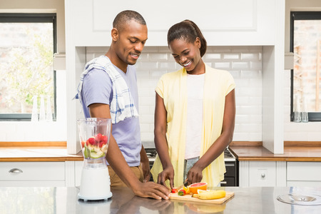 Young casual couple making fruits in the kitchen