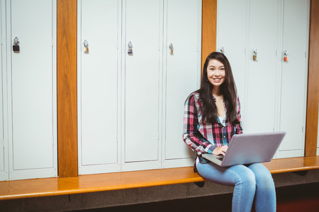 Smiling student sitting at the computer at the universityの写真素材