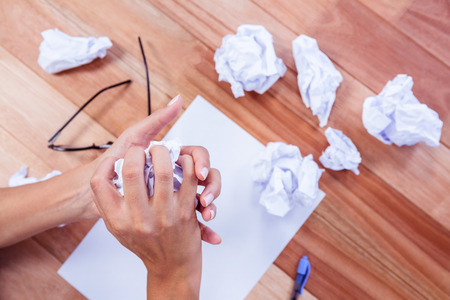 Part of hands making paper ball on wooden deskの写真素材