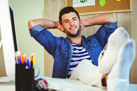 Handsome hipster working at desk in his officeの写真素材