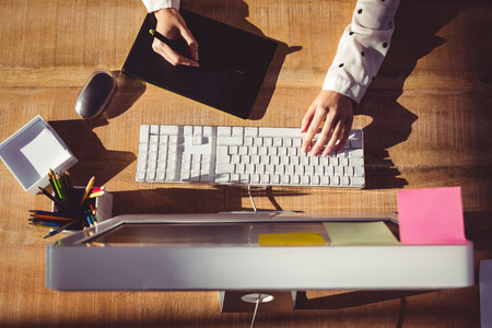 Cropped image of woman using graphics tablet in her officeの写真素材
