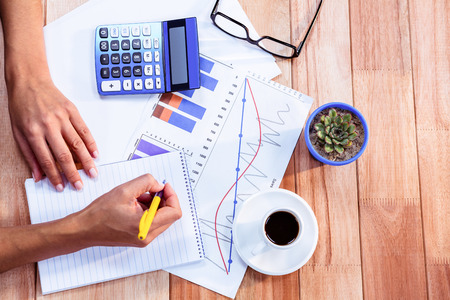 Woman doing some banking at home on wooden desk