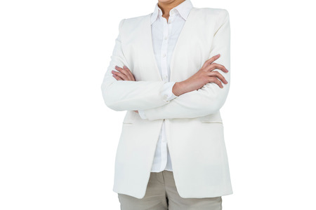 Business woman with folded arms against white backgroundの写真素材