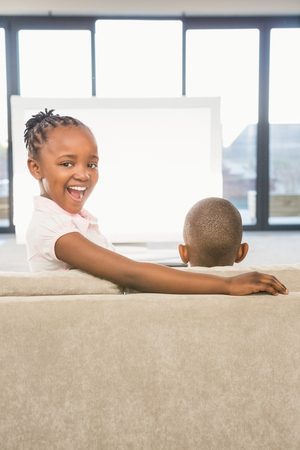 Two children sitting on sofa in living roomの写真素材