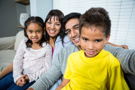 Cut out of family taking a selfie on sofa in living roomの写真素材