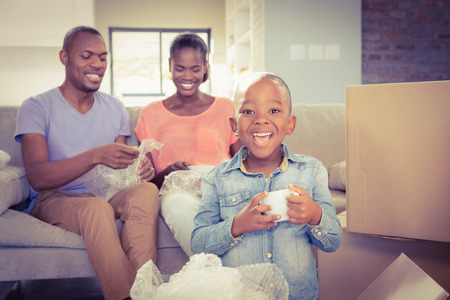 Family unwrapping things in new home in living roomの写真素材