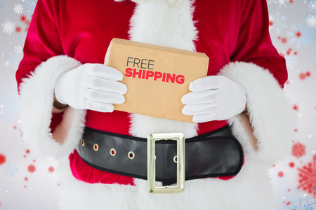 Mid section of santa claus holding box against snowflake patternの写真素材