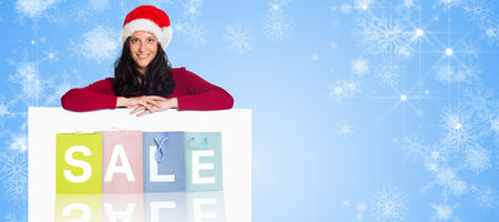Woman smiling at the camera against white snowflake design on blueの写真素材