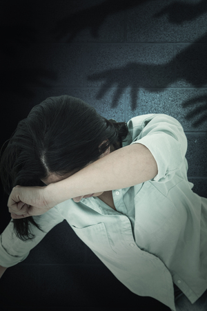 Hand of a businessman writing with a chalk against dark grey roomの写真素材