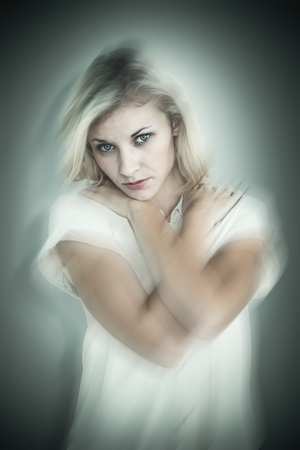 Sad pretty blonde looking at camera against grey vignette