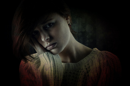 Pretty brunette feeling sad  against dark background