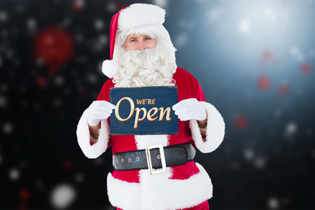 Smiling santa claus holding page against vintage open sign