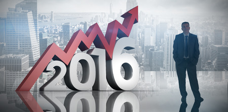 Businessman standing against room with large window looking on cityの写真素材