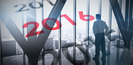 Businessman standing against room with large window looking on city