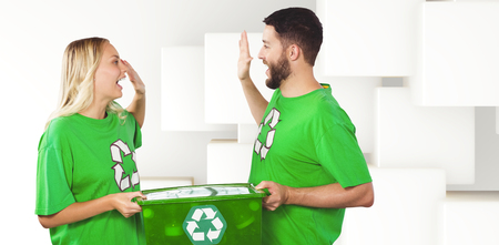 Smiling volunteer doing high five while holding container  against abstract white designの写真素材