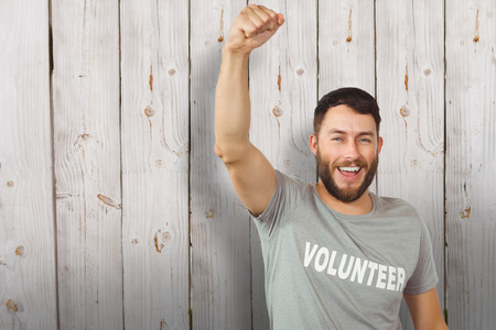 Portrait of cheerful volunteer  against wooden backgroundの写真素材
