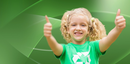 Happy little girl in green with thumbs up  against abstract green designの写真素材