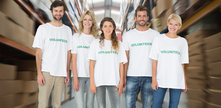 Group portrait of happy volunteers against shelves with boxes in warehouseの写真素材