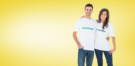Two cheerful people wearing volunteer tshirt against yellow vignetteの写真素材