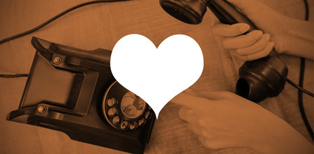 Heart against parts of hands using old phoneの写真素材