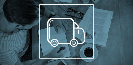 lorry against man writing while sitting by deskの写真素材