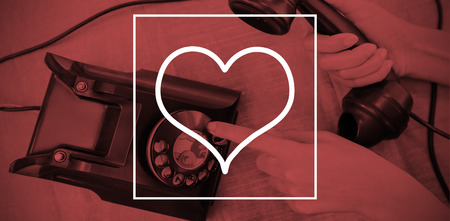 Heart against parts of hands using old phoneの写真素材