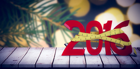 2016 with measuring tape against fir tree branch with green needles