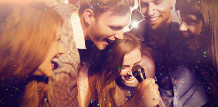 Flying colours against happy friends singing karaoke together