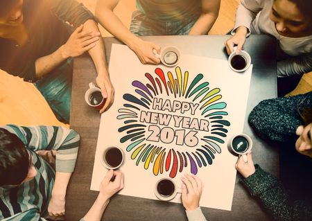 People sitting around table drinking coffee against new year graphicの写真素材